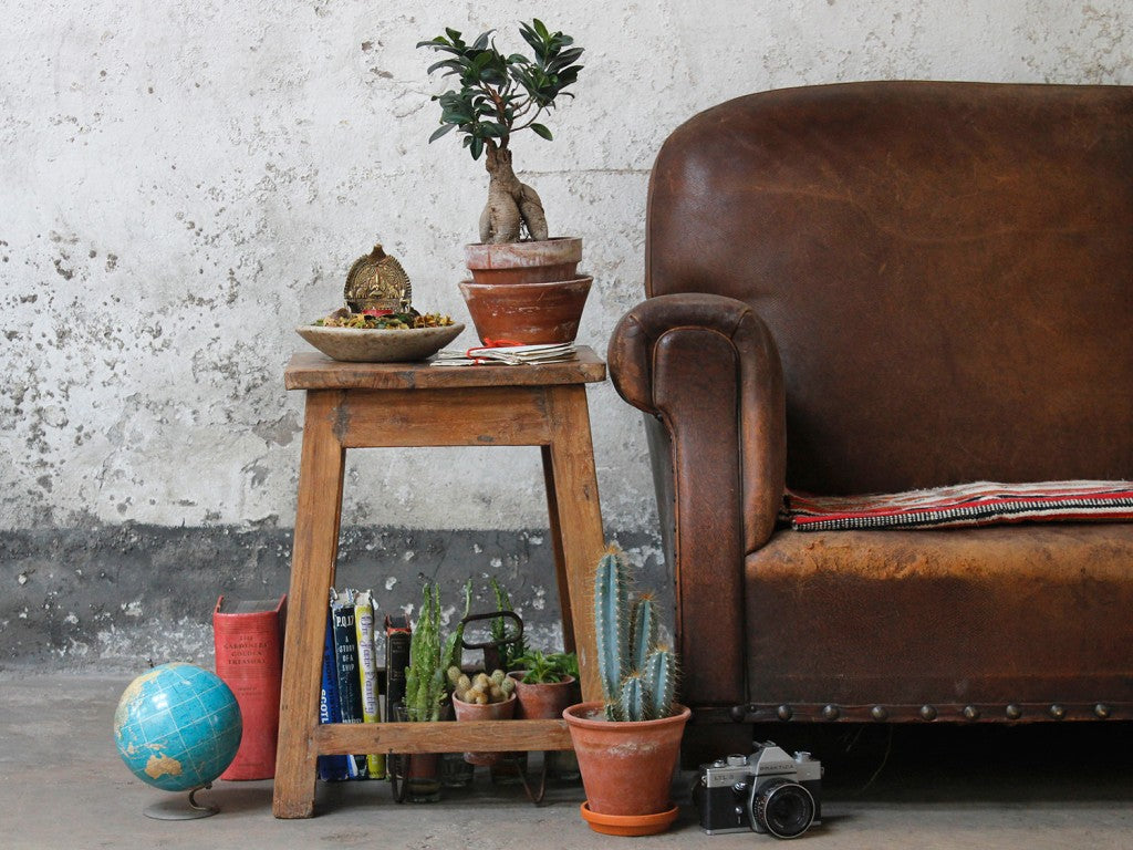 A vintage school stool used as a side table